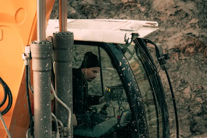 Grävmaskinist Kristoffer Persson sitter i grävmaskinens hytt, redo att prova hydraulhammaren.