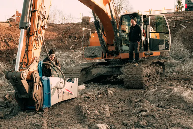 Grävmaskinisten Kristoffer Persson ståendes på larven på Liebherr 936LC.