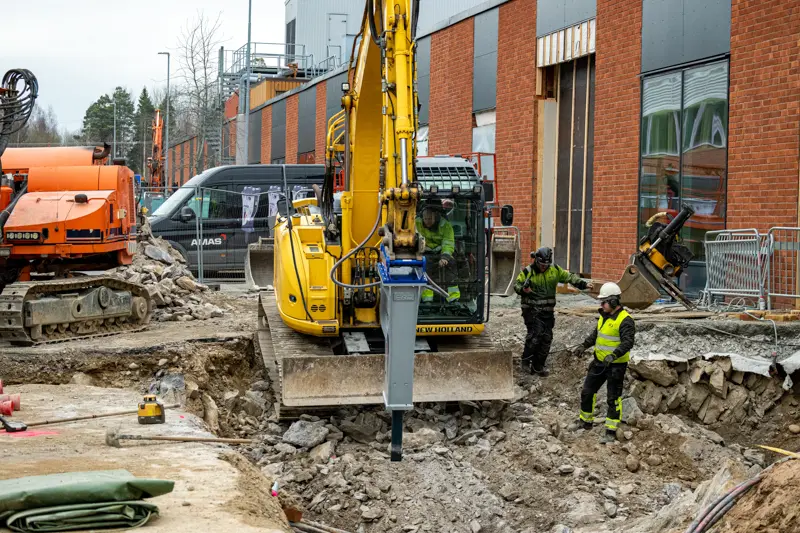 Grävmaskin på väg att banda ner i rörgrav för att testa hydraulhammaren.