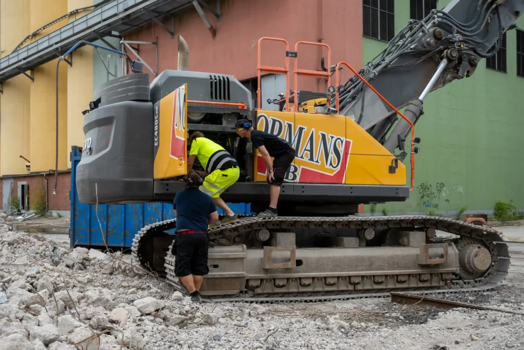Inspektion av vattenpumpen i motorutrymmet på en VOlvo grävmaskin.