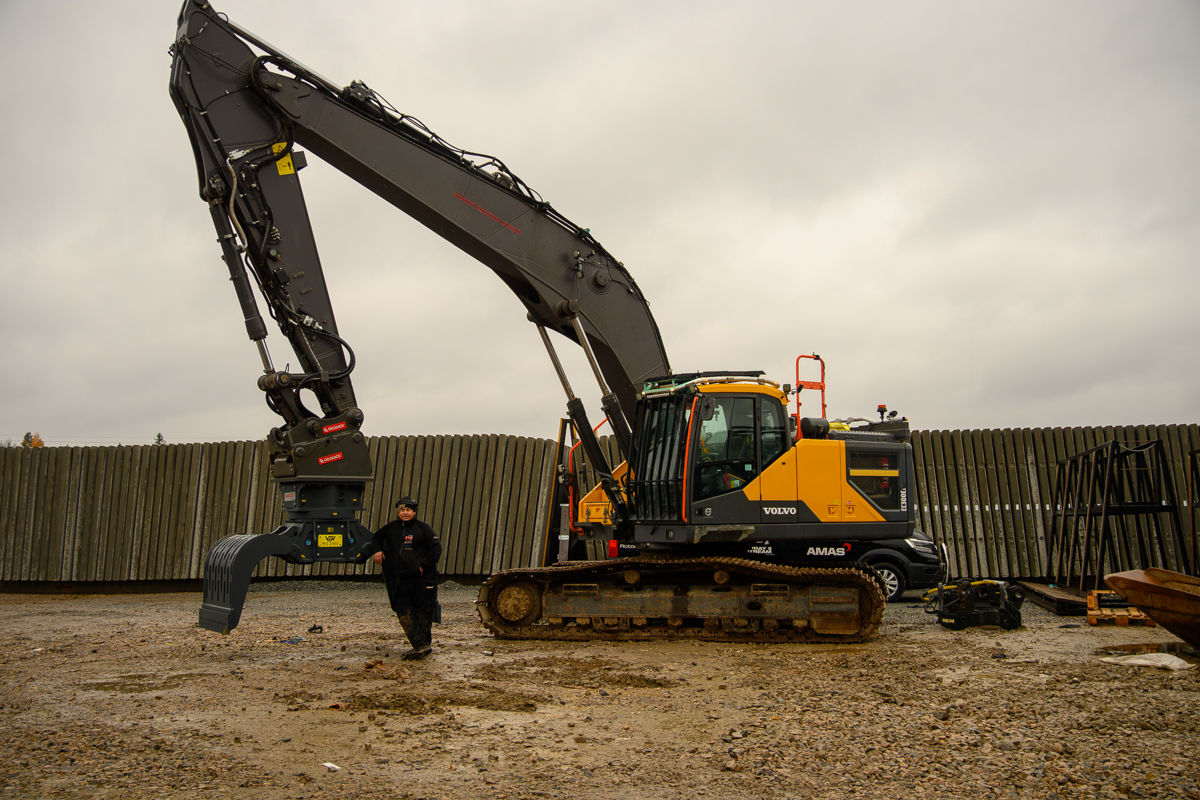 Volvo grävmaskin utrustad med rivningsgrip och sorteringsgrip från AMAS, visad på arbetsplats inför rivning och materialhantering.